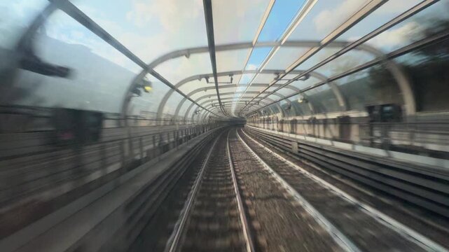 POV from a metro train driver cab on outdoor section, between stations with fast motion rails and city scenery creating an immersive urban transportation ride