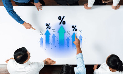 Dynamic interaction among a diverse business team focused on financial growth strategies, visualizing progress with upward arrows and percentages on a meeting table. Trope
