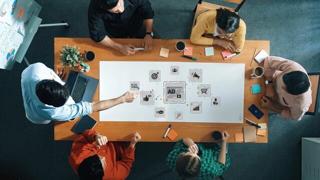 A dynamic group of individuals engages in a collaborative brainstorming session, sharing innovative marketing ideas and strategizing in a modern office environment. Raster