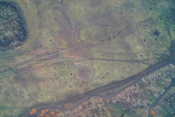 Aerial top down view of anti-tank obstacles, trenches and shell craters. War zone multi-layered defense fortification and scarred field texture background.