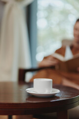 Cozy indoor scene featuring a woman in a brown robe enjoying a cup of tea, promoting relaxation and comfort in a serene atmosphere