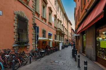 Old narrow street with tables of restaurant in Bologna, Emilia Romagna, Italy. Architecture and landmark of Bologna. Cityscape of Bologna. © Ekaterina Belova
