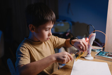 Teenage boy meticulously creates prototype circuits in evening hours