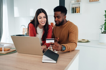Diverse couple buying goods online using credit card