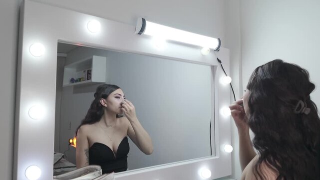 Makeup artist dabs sponge across face to even complexion