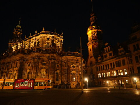 Illuminated tram in front of historic architecture in Dresden at night. Catholic Court Church. Copyspace