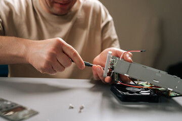 Close-up of man focusing on repairing internal computer hardware components with screwdriver, demonstrating expertise in electronics maintenance and technical servicing. Concept of technical support.