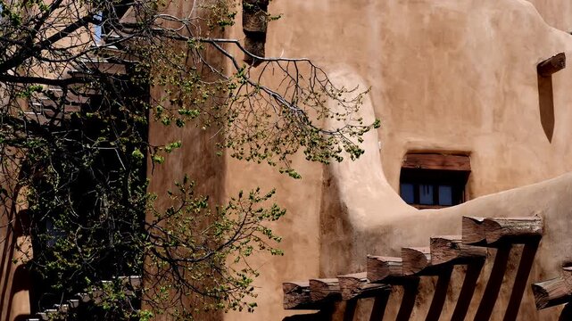 Trees and shrubs frame historic 19th and 20th century buildings in and around the Plaza in Santa Fe, New Mexico, USA