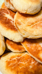 Close up of a pile of traditional homemade golden brown baked or fried pies