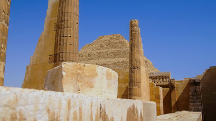 Ancient stone columns and ruins near the Step Pyramid in Egypt, showcasing historic architecture during a travel vacation.