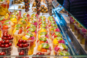 fresh fruit salad cups healthy convenience snack pre cut tropical fruit arranged in rows on refrigerated market display street food concept of diet eating gourmet travel