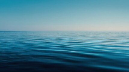 Obraz premium The water stretches far across the horizon with subtle waves reflecting the sky. The scene shows a clear blue atmosphere with no visible land. It captures a calm and open ocean.