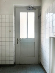 Bright, minimalist interior with a white door in a tiled, no person