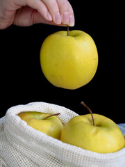 Hands Holding Yellow Apple Above Reusable Produce Bag - Sustainable Plastic Free Fruit Shopping