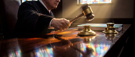 Judge holds gavel in courtroom during a legal proceeding on a weekday