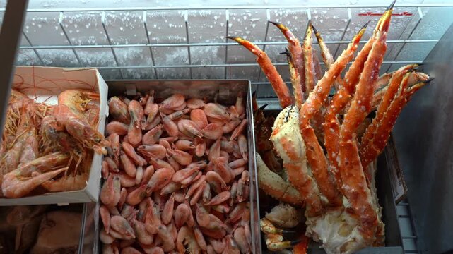 Freezer filled with various frozen seafood including crabs, shrimps, and crustaceans, showcasing fresh and high-quality products for sale or storage