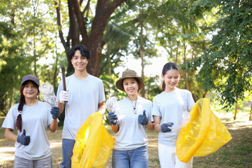 Group of Young Volunteer Help Cleaning Public Park Collecting Garbages and Plastic Waste