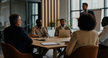 Business meeting with presenter addressing diverse team around conference table