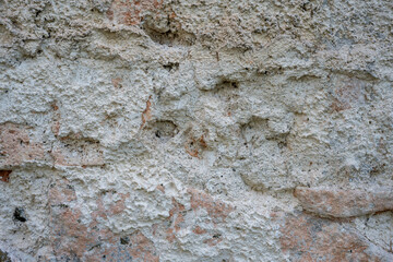 Detailed texture of an old red brick wall showing wear, surface flaking, and weathered mortar. A natural, realistic background for architectural or design applications.
