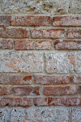 Close-up texture of an old red brick wall with chipped surfaces, weathered mortar, and natural aging. Ideal for backgrounds, architecture projects, and grunge-style design elements.