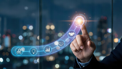 Finger activating luminous interface with icons representing technology, innovation, and business growth against city skyline at night. image conveys sense of progress and connection