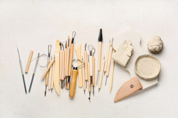Set of sculptor tools with plaster figure and clay on white grunge background