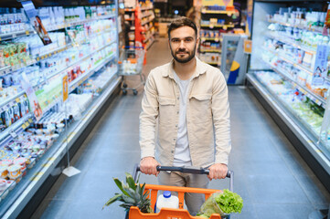Man shopping for groceries in supermarket aisle