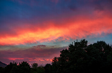Clouds turn bright colors at sunset from wildfire smoke in the air