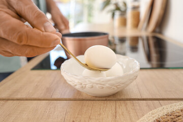 Mature man boiling eggs in kitchen, closeup