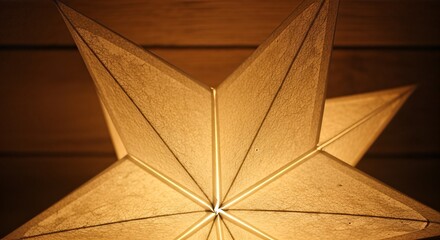 Close-up of a glowing, warm golden star-shaped paper lantern illuminating a dark room.