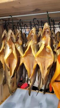 Hanging golden smoked trout in a smokehouse