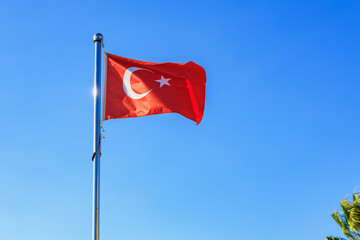 Turkish flag waving against clear blue sky