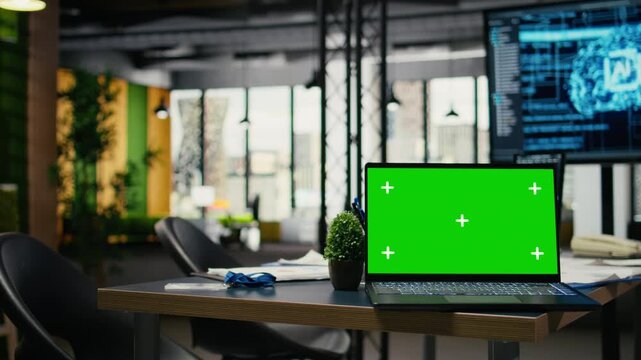 Green screen laptop in empty office used to accelerate complex artificial intelligence calculations. Close up of mockup notebook used for deep learning training datasets systems, camera A