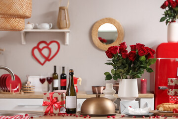 Vase with roses, cloche and presents on counter in kitchen decorated for Valentine's Day