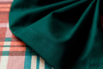 Corner of green table runner on plaid holiday table