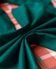 Corner of green table runner on plaid holiday table