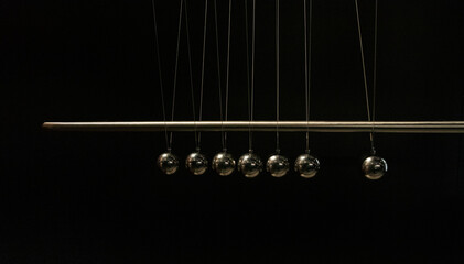 physical experiment showing the transition of kinetic energy into potential energy on a matte black background