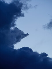 Fototapeta premium Dramatic time-lapse footage of menacing deep blue storm clouds gathering on the edges of the frame. A highly atmospheric sky background capturing severe impending weather conditions.