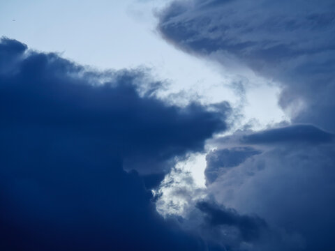 Time-lapse footage of menacing deep blue storm clouds gathering in the dark sky. A highly atmospheric and moody meteorological background capturing changing severe weather conditions.