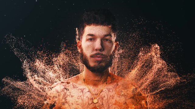 Digital portrait of a young tattooed man dissolving into a glowing cloud of golden particles. Futuristic 3d scanning effect on a male model