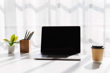 Laptop with blank screen on white table on grey background. blank screen on white grey background. 
