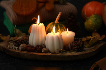 Composition with candles, pumpkins and beautiful autumn decor on dark background