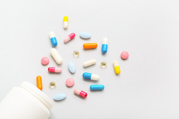 Composition with colorful pills and bottle on grey background