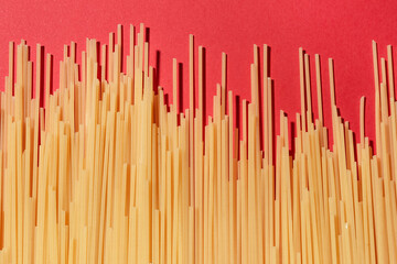 Uncooked spaghetti pasta on red background