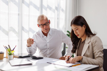 Team of business using calculator and laptop for do math finance on wooden desk in office and business working background, tax, accounting, statistics and analytical research concept
