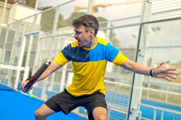 Family team mx. Group of two mix padel tennis players with racket. Woman and man athletes with paddle racket on the blue court. Sport concept. Download a high quality photo for a sports app.