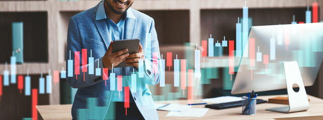 A cheerful Indian professional is browsing the web on a digital tablet in a contemporary office. He is smiling while engaging with technology in a productive work setting.