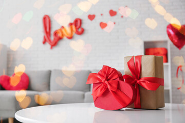 Table with gift boxes in stylish living room, closeup. Valentine's Day celebration