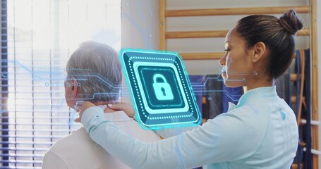 Assessing therapist placing hands on senior man's neck in therapy room, light blue top, AR lock