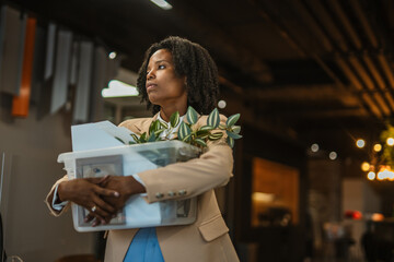Employee leaving office with personal belongings after layoff